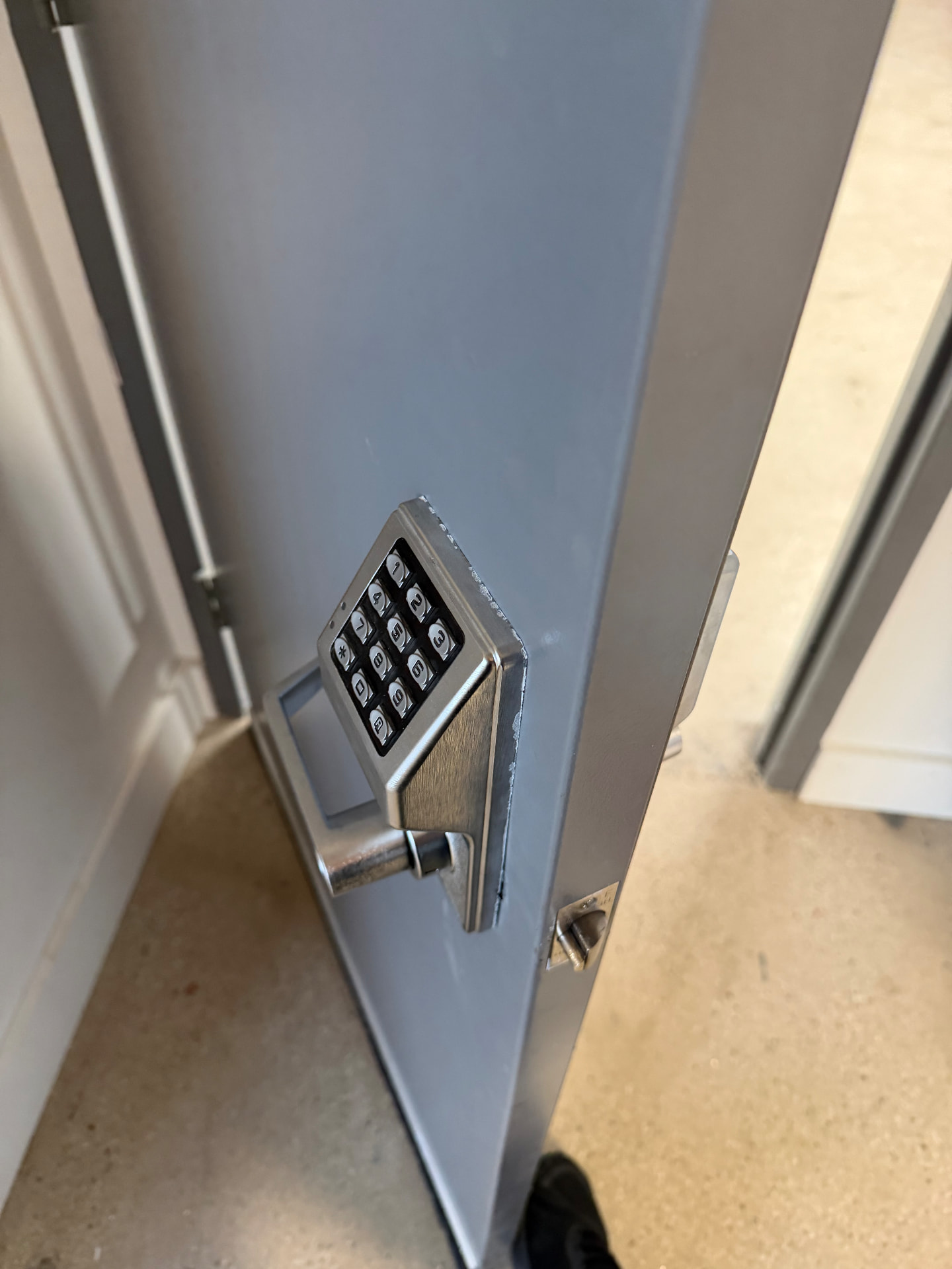 Commercial keypad lock installed on a grey steel door
